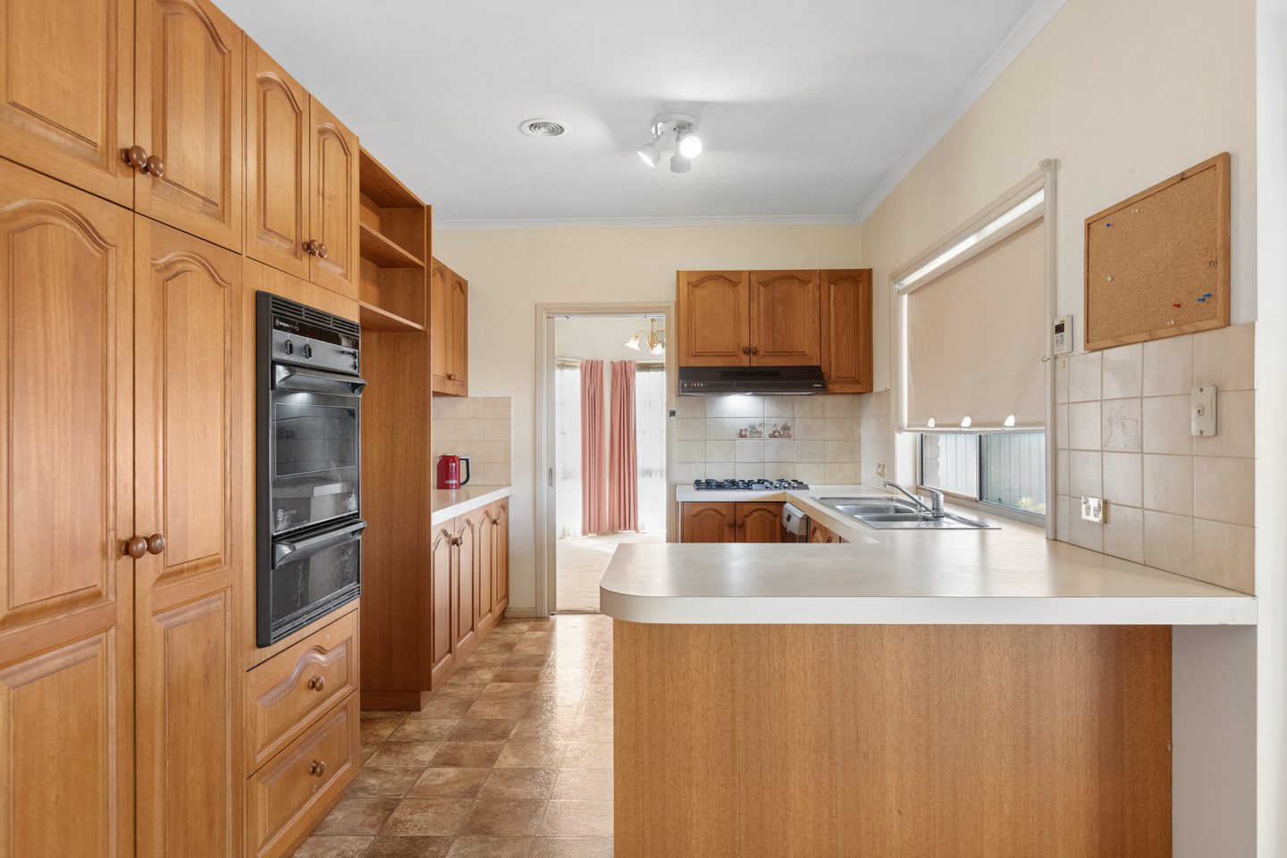 Timber kitchen with a breakfast bar, gas cooktop, wall oven and dishwasher